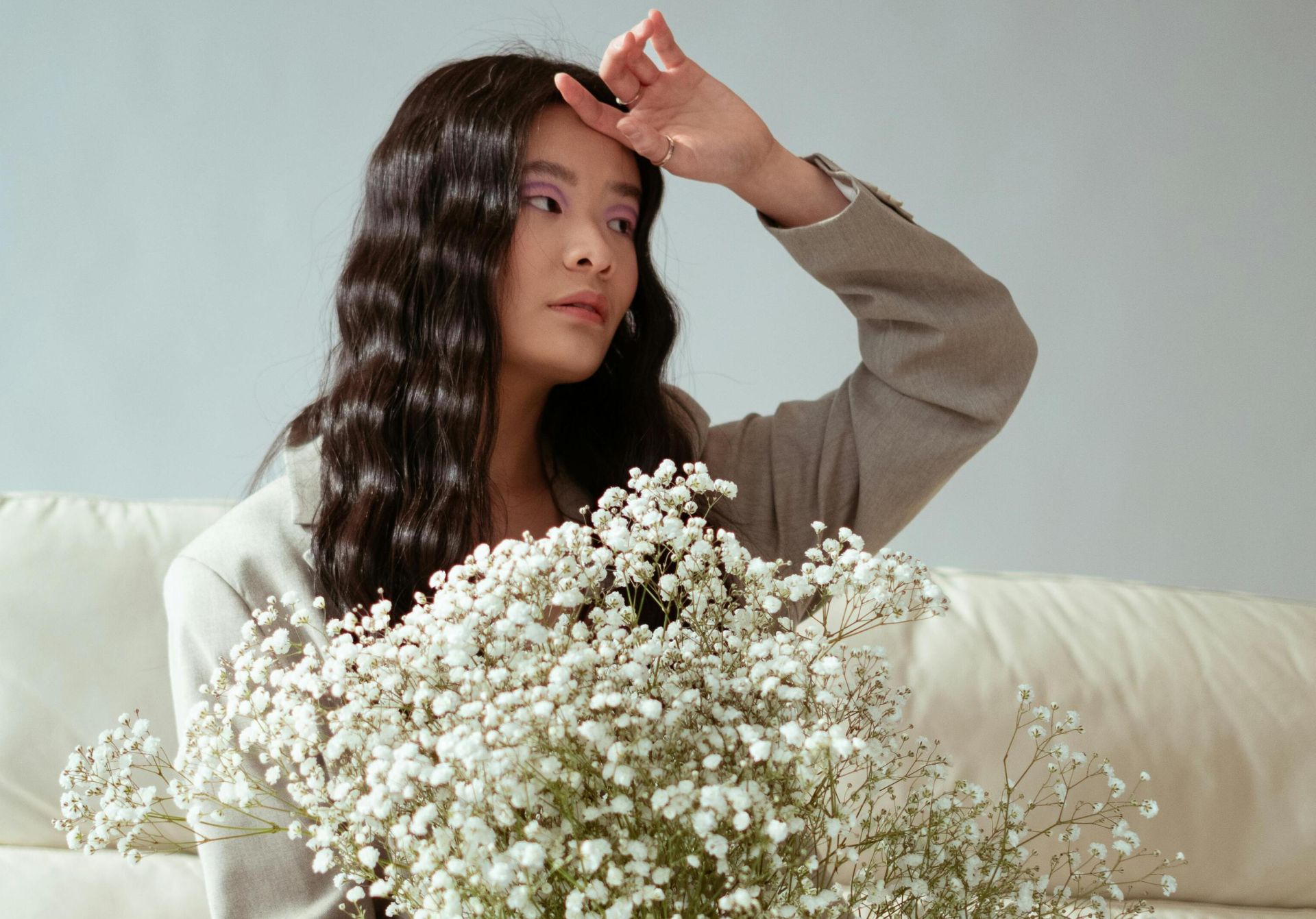 Portrait of a stylish woman holding white flowers, indoors.