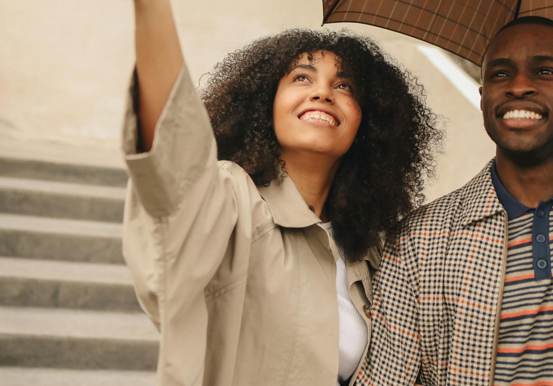 Joyful couple with umbrella enjoying an outdoor moment together.