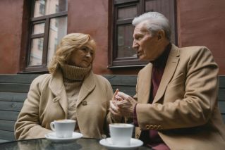 Senior couple sharing an intimate moment over coffee in a cozy setting, showcasing love and connection.