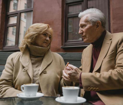 Senior couple sharing an intimate moment over coffee in a cozy setting, showcasing love and connection.